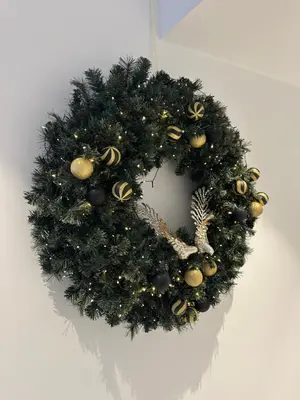a christmas wreath on a white wall with at Nesseus Lux Suites - Near Unic & EUC in Ayios Dhometios