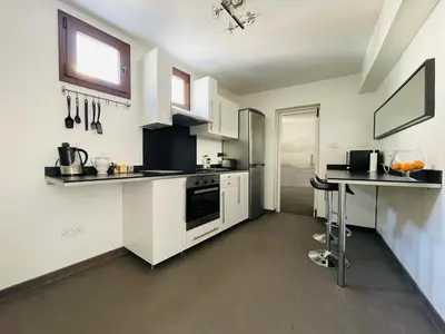 a kitchen with white appliances and a table in it at Olistay in Voroklini