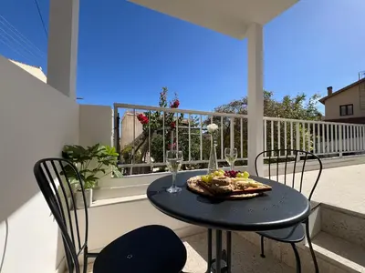 a table with a plate of food on a balcony at Olistay in Voroklini
