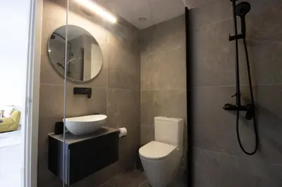 a bathroom with a toilet and a sink and a shower at Modern City Retreat - Balcony and Chic Design in Nicosia