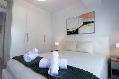 a bedroom with a white bed with towels on it at Modern City Retreat - Balcony and Chic Design in Nicosia