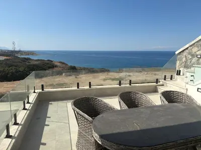 a table and chairs on a balcony overlooking the ocean at Poseidon North Ciprus, Tatlisu