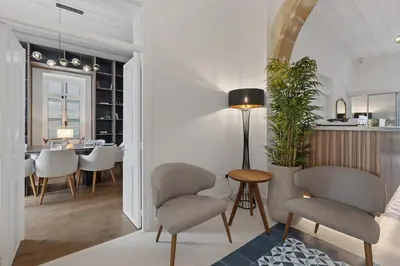 a living room with chairs and a dining room at Warner Boutique Hotel-Adults Only in Larnaka