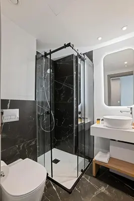 a bathroom with a shower and a toilet and a sink at Warner Boutique Hotel-Adults Only in Larnaka