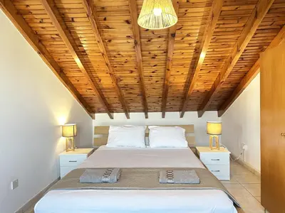 a bedroom with a bed with a wooden ceiling at Serenity in the Sun - Holiday Apt - Larnaca in Larnaka