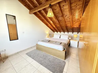 a bedroom with a bed and a wooden ceiling at Serenity in the Sun - Holiday Apt - Larnaca in Larnaka