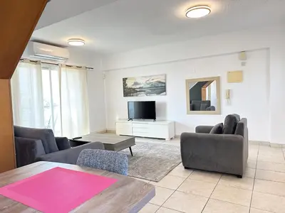 a living room with two couches and a tv at Serenity in the Sun - Holiday Apt - Larnaca in Larnaka