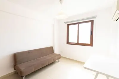 a couch in a room with a window at Spacious & Bright Apartment with Balcony in Larnaka