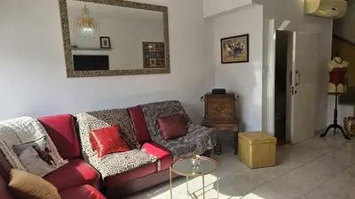 a living room with a red couch and a mirror at STAY Alex's House in Strovolos