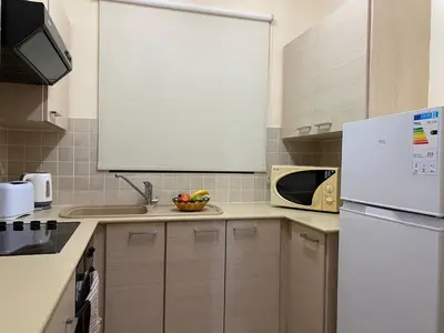 a kitchen with a white refrigerator and a microwave at Kyklades Resort & Spa in Paralimni