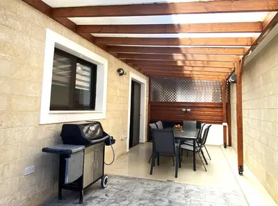 a patio with a table and chairs and a television at Kyklades Resort & Spa in Paralimni