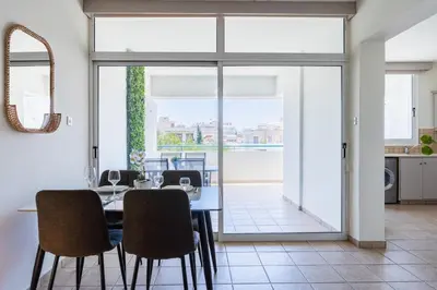 a kitchen and dining room with a table and chairs at Yellow Canvas - 2-BR Apartment & Balcony in Larnaca in Larnaka
