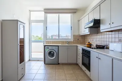 a kitchen with a washing machine and a window at Yellow Canvas - 2-BR Apartment & Balcony in Larnaca in Larnaka