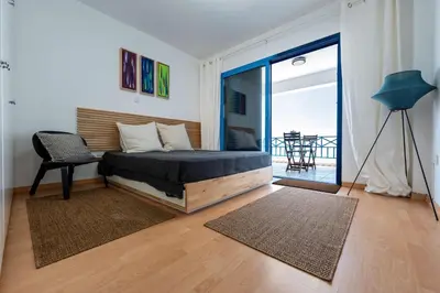 a bedroom with a bed and a balcony with a table at Beachfront Mediterranean Escape 3bd Sea View Apartment in Pendakomo