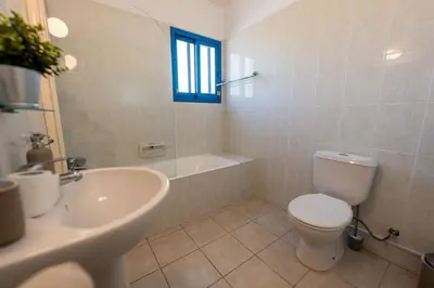 a bathroom with a toilet and a sink and a tub at Beachfront Mediterranean Escape 3bd Sea View Apartment in Pendakomo