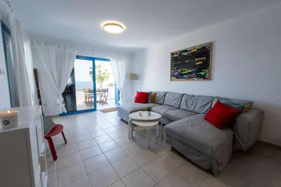a living room with a couch and a table at Beachfront Mediterranean Escape 3bd Sea View Apartment in Pendakomo