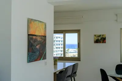 a dining room with two pieces of art on the wall at Downtown Sea View Penthouse in Larnaka