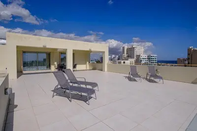 a patio with chairs on top of a building at Downtown Sea View Penthouse in Larnaka
