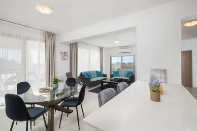 a living room with a glass table and chairs at Downtown Sea View Penthouse in Larnaka