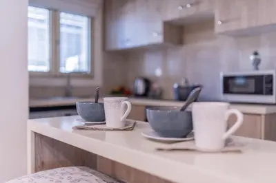 a kitchen with three cups and saucers on a counter at Finikoudes gate in Larnaka