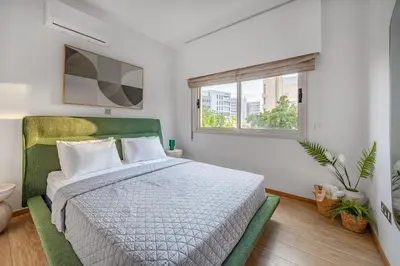 a bedroom with a large bed and a window at Lena Court - Spacious 3bdr, City Views in Limassol