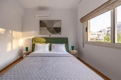 a bedroom with a large bed and a window at Lena Court - Spacious 3bdr, City Views in Limassol