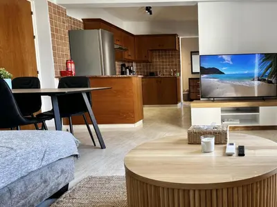 a living room with a table and a kitchen at STAY Paradise Apartment in Protaras