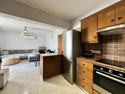a kitchen with a stainless steel refrigerator and a living room at STAY Paradise Apartment in Protaras