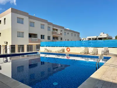a swimming pool in front of a building at STAY Paradise Apartment in Protaras