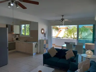 a living room with a blue couch and a kitchen at Casa Luna in Paralimni