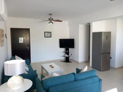 a living room with a blue couch and a tv at Casa Luna in Paralimni