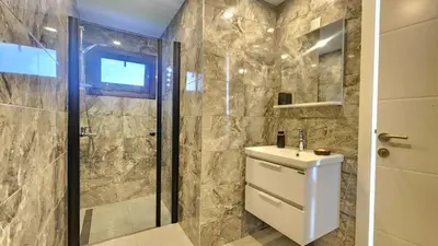 a bathroom with a toilet and a sink and a shower at Idyll Homes THE PENTHOUSE in Avdhelleron
