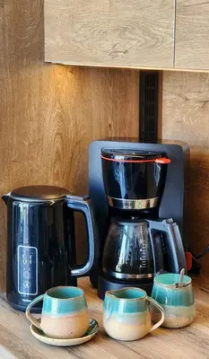a counter with a coffee maker and three cups at Idyll Homes THE PENTHOUSE in Avdhelleron