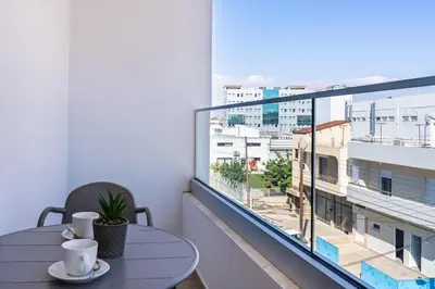 a table on a balcony with a view of a city at Hilltop 2-Bedroom Apartment in Larnaka