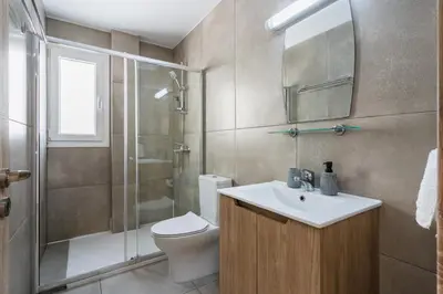 a bathroom with a toilet and a sink and a shower at Hilltop 2-Bedroom Apartment in Larnaka