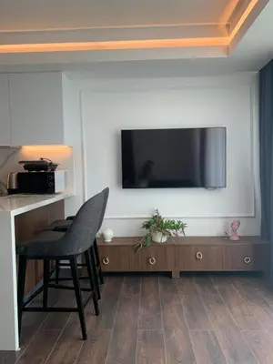 a room with a chair and a television on a wall at Grand Shapphire 4 apartments SEA VIEW in Paralimni