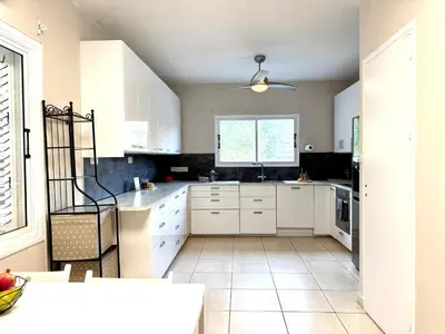 a kitchen with white cabinets and a window at Onyx Beach Villa - Cozy 2BR - Walk to Beach in Meneou