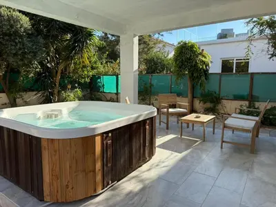 a hot tub on a patio with a table and chairs at Onyx Beach Villa - Cozy 2BR - Walk to Beach in Meneou