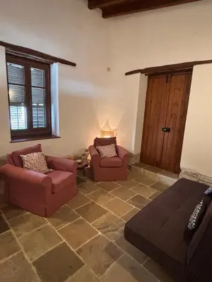 a living room with two chairs and a door at Calypso Historic Village House in Limassol