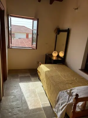 a bedroom with a bed and a window and a mirror at Calypso Historic Village House in Limassol