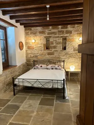 a bedroom with a bed in a brick wall at Calypso Historic Village House in Limassol