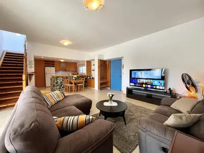 a living room with two couches and a flat screen tv at STAY Agapi Sea view Villa in Pissouri