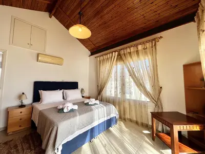 a bedroom with a bed and a window and a table at STAY Agapi Sea view Villa in Pissouri