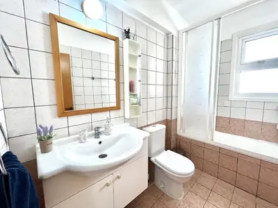 a bathroom with a sink and a toilet and a mirror at STAY Agapi Sea view Villa in Pissouri