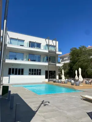 a building with a swimming pool in front of a building at Amalfi Suite at Mythical Sands Resort in Paralimni