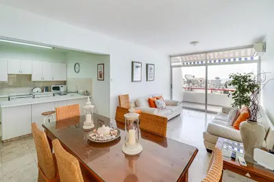 a kitchen and living room with a table and chairs at Family Friendly 2-Bed on Limassol Seafront in Limassol
