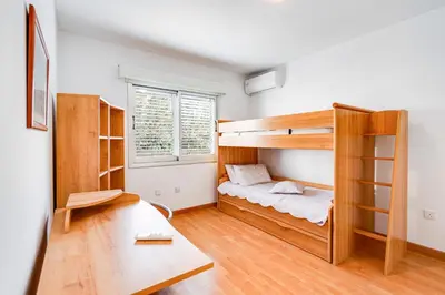 a bedroom with a bunk bed and a desk at Family Friendly 2-Bed on Limassol Seafront in Limassol