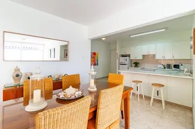 a kitchen and dining room with a table and chairs at Family Friendly 2-Bed on Limassol Seafront in Limassol