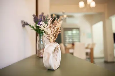 a vase filled with dried flowers on a table at Bluewave Apartment in Pyla