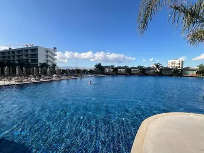 a large swimming pool with blue water and umbrellas at Grand Sapphire,Luxury Residence BY Report Homes Northern Cyprus in Ayia Napa
